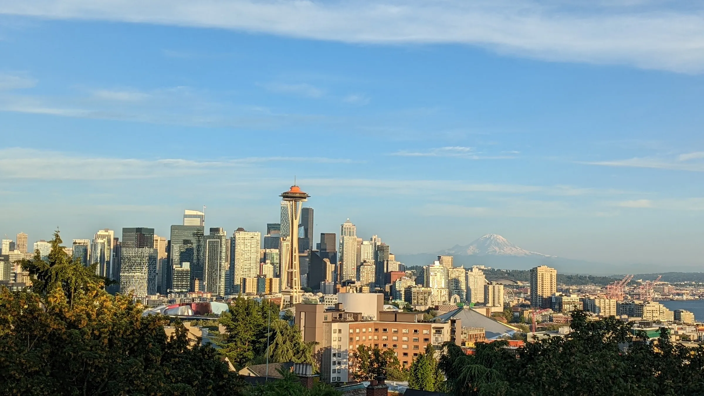 Seattle skyline with Space Needle and Mount Rainier visible in distance on clear day